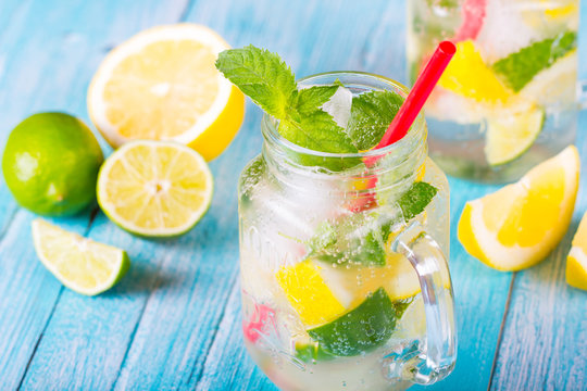 citrus fresh lemonade soda ice mint lemon lime wooden background
