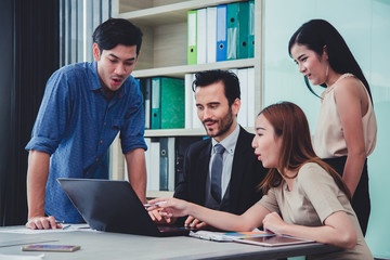 Happy Successful multiracial business team giving a high fives gesture as they laugh and cheer their success..