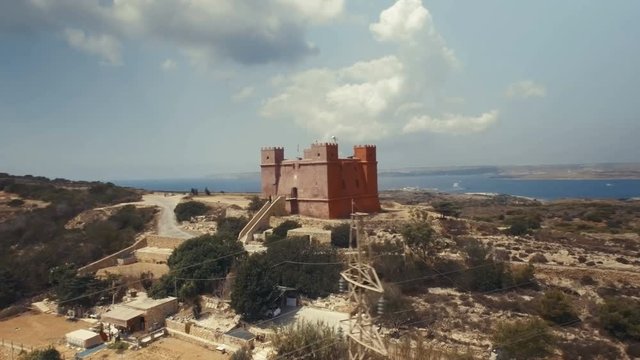 Aerial shot rotating around St Agatha's Red Tower in Mellieha Malta