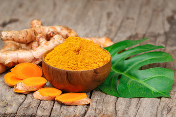 Turmeric powder in wooden bowls on wooden table