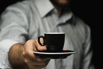 A man is holding a mug of coffee