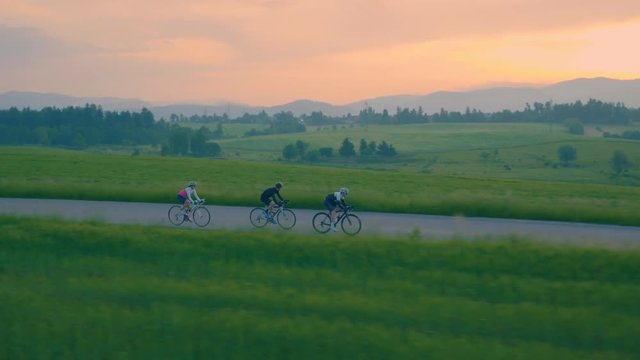 Aerial tracking of a group of road cyclists early in the morning in the countryside