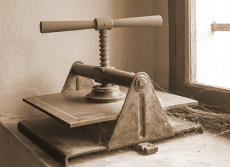 Retro book press on the window in sepia color