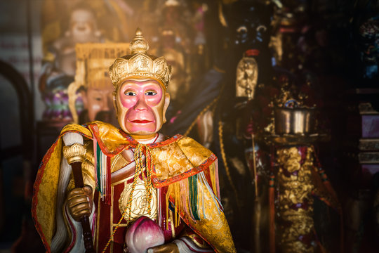 Red and golden colored statue of monkey spirit in holy buddhist temple in thailand with bokeh