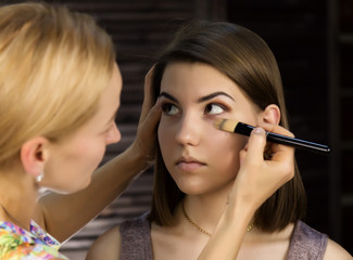 Professional make-up artist makes eye makeup on a client face. beauty fashion industry