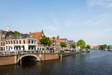 Fototapeta na wymiar Traditional Dutch houses along a canal on a sunny day in Haarlem in the Netherlands, Europe