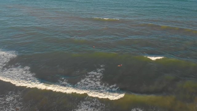 Surfers waiting for waves on a blue sea in Aracaj&uacute;, Sergipe, Brazil