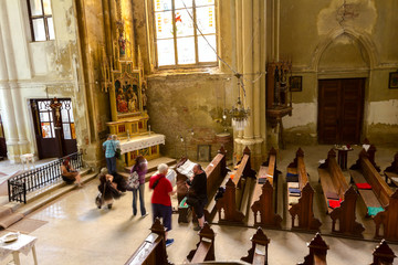 Young model poses for a creative group of photographers in ancient German Catholic Church
