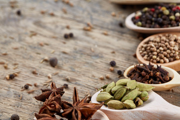 Colourful aromatic various spices for cooking on old wooden board, close-up, flat lay, selective focus.