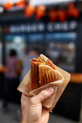 First person view shot of a man eating hamburger in the street cafe, soft focus, shallow depth of field.