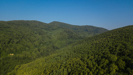 Obraz premium Russian Forest And Mountains Under Blue Sky By Aerial Drone. Stunning Aerial Drone Stock Footage of South russian Forest And Mountains Under Blue Sky
