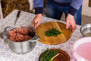 Man adds greens to the minced meat. Preparation of stuffing for kebab. Photo set