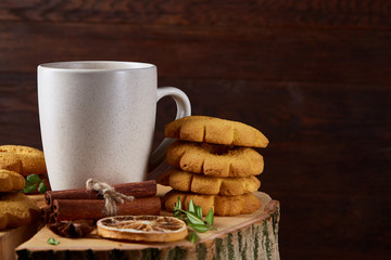 Christmas teatime with oatmeal, chocolate biscuits, and spices, on wooden background, close-up, selective focus.