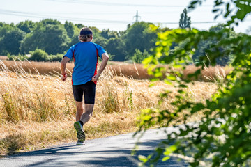 Man running next to field during harvest time