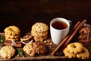 Christmas teatime with oatmeal, chocolate biscuits, and spices, on wooden background, close-up, selective focus.