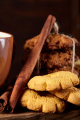 Christmas teatime with oatmeal, chocolate biscuits, and spices, on wooden background, close-up, selective focus.