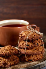 Christmas teatime with oatmeal, chocolate biscuits, and spices, on wooden background, close-up, selective focus.