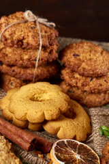 Conceptual composition with assortment of cookies and cinnamon with napkin on a wooden barrel, selective focus