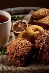 Christmas teatime with oatmeal, chocolate biscuits, and spices, on wooden background, close-up, selective focus.