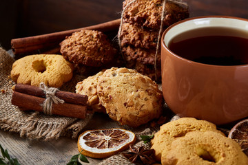 Cookies with cinnamon and two cups of tea on a burlap napkin, selective focus, close-up, top view.