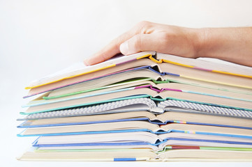 Open school books lie one on one on a gray background. On the books there is a hand. Educational school concept