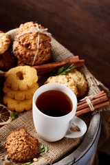Cookies with cinnamon and two cups of tea on a burlap napkin, selective focus, close-up, top view.