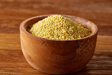 Lentils in a wooden bowl on rustic wooden background, top view, close-up, selective focus.