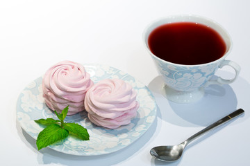 Red hibiscus tea (sudan rose tea) with pink blueberry marshmallow. Sweets decorated with pepper mint.