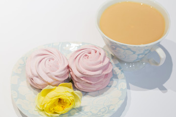 Tea time with homemade pink marshmallow. Black tea with milk, sweet souffle and yellow rose.