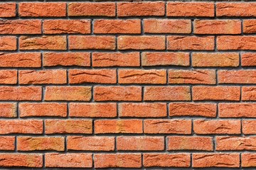 Red brick wall. Decorative brick with artificial defects and cracks.