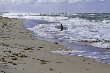 Surfer an der Küste vor Kampen auf Sylt bei sonnigem Wetter.