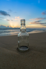 Glass bottle with beatiful beach sunset landscape