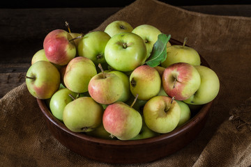 Ripe red and green apples on wooden background. Apples in bowl. Garden fruits. Autumn fruits. Autumn harvest.