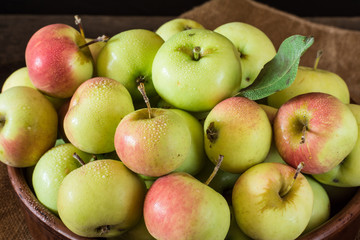 Ripe red and green apples on wooden background. Apples in bowl. Garden fruits. Autumn fruits. Autumn harvest.