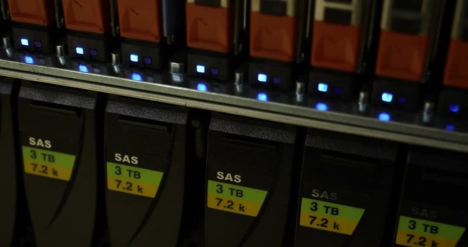 Details of a storage array in a modern data center with lot of connectors and blinking leds