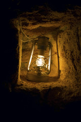Futuristic electric street lamp glowing in a dark stone cave.