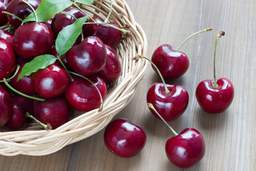 Fresh cherry in basket on wooden background