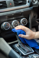 Auto service worker cleaning inside car with micro fiber cloth