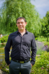 Middle age arabic  smiling man in black shirt at park with good mood 