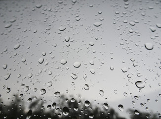 Large drops of rain on the windshield of the car
