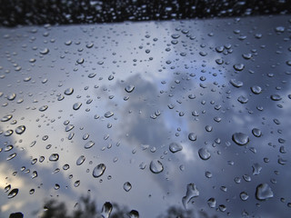 Large drops of rain on the windshield of the car