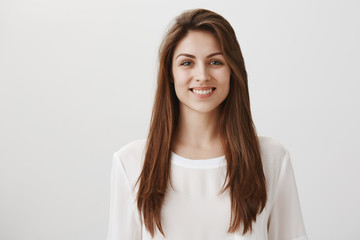 Creating success with her own hands. Portrait of pleased beautiful girl with shiny smile in white...