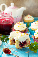 Colorful orange cupcake birthday with raspberry jam close-up on a wooden table.