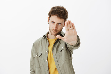 Stop, leave me alone. Displeased annoyed attractive male with beard in casual clothes, looking from...