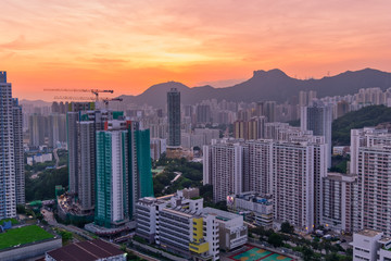 Naklejka na ściany i meble Kowloon Residential Building and Urban Skyscrapers Under Mountains Lion Rock Summer Sunset Landscape with Dramatic Sky