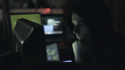 Young hacker connecting online with his computer