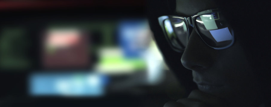 Nerd hacker with glasses in the dark