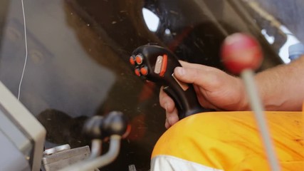 Operator is operating excavator on a modern construction site using joysticks