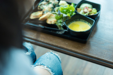 Women with healthy food menu at the restaurant on the wooden table, she enjoy eating.
