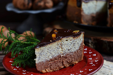Fototapeta na wymiar A piece of chocolate cheesecake with poppy seeds on a red saucer